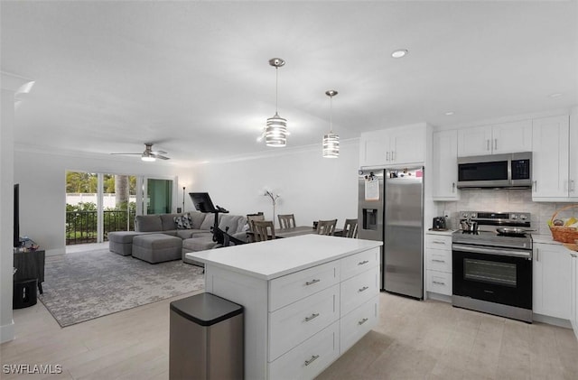 kitchen with white cabinetry, light countertops, appliances with stainless steel finishes, decorative backsplash, and a center island