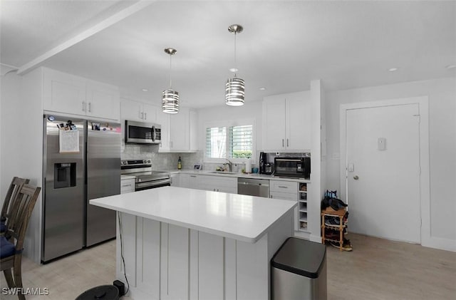 kitchen with tasteful backsplash, appliances with stainless steel finishes, light countertops, and a sink