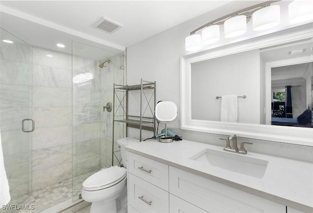 full bathroom featuring toilet, vanity, a shower stall, and visible vents