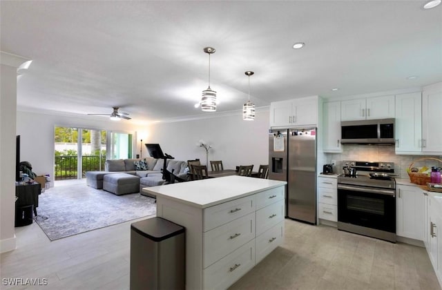 kitchen featuring stainless steel appliances, a center island, white cabinets, and decorative backsplash