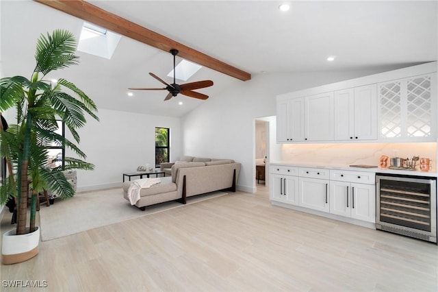 living area with lofted ceiling with beams, ceiling fan, wine cooler, light wood-type flooring, and recessed lighting