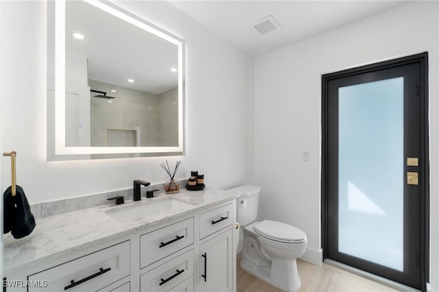 full bath featuring visible vents, toilet, walk in shower, vanity, and recessed lighting