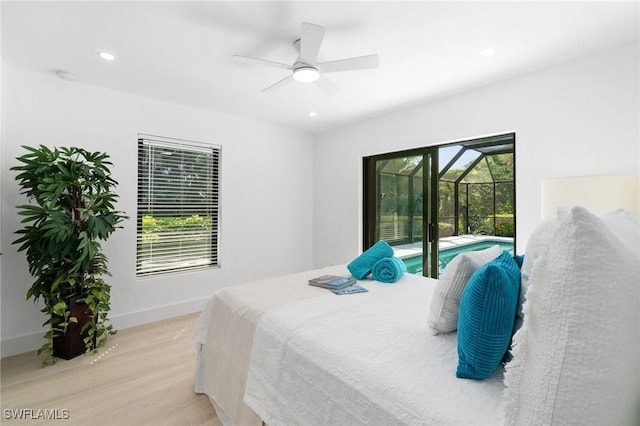 bedroom featuring access to exterior, multiple windows, light wood-style floors, and a sunroom