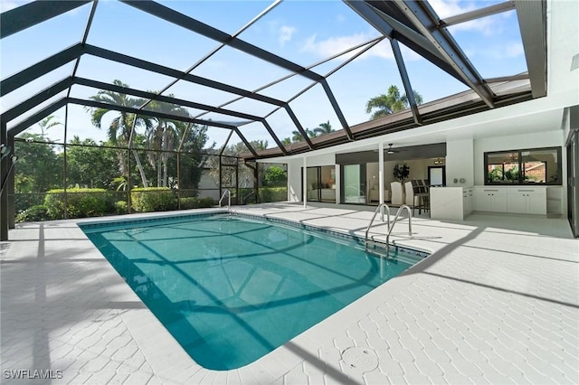 pool featuring glass enclosure and a patio area