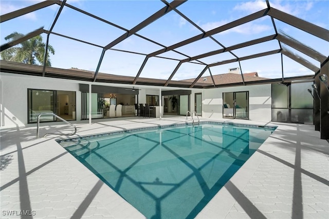 outdoor pool with glass enclosure and a patio area