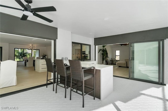 kitchen with light wood-style floors, a wealth of natural light, open floor plan, and a kitchen bar