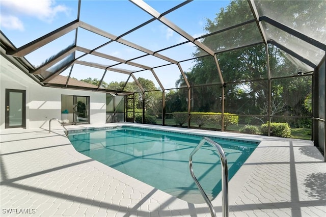 outdoor pool with glass enclosure and a patio