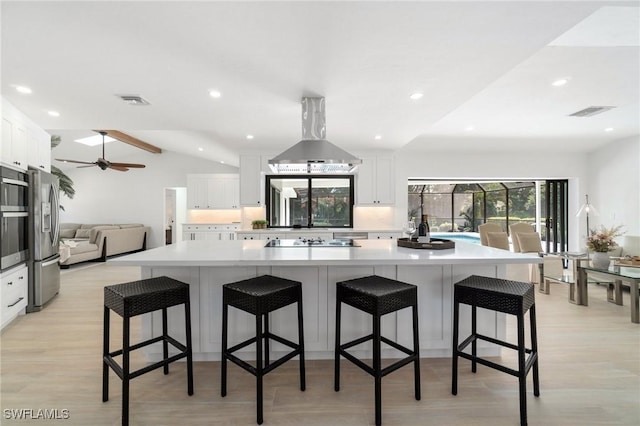 kitchen featuring a breakfast bar, white cabinets, a large island, and island range hood