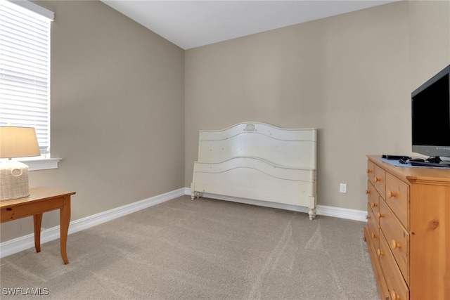 bedroom with light carpet, multiple windows, and baseboards