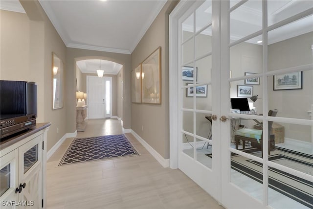 foyer entrance with baseboards, arched walkways, crown molding, and french doors