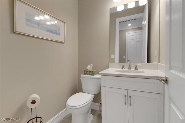 half bathroom with toilet, baseboards, visible vents, and vanity