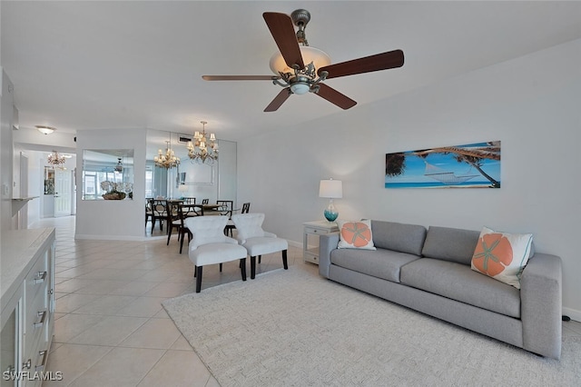 living area featuring light tile patterned floors, baseboards, and ceiling fan with notable chandelier