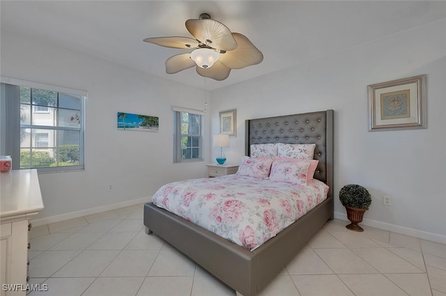 bedroom with light tile patterned flooring, ceiling fan, and baseboards