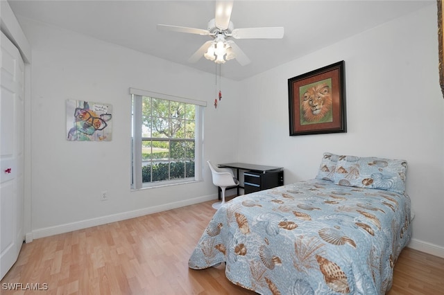 bedroom with ceiling fan, wood finished floors, and baseboards