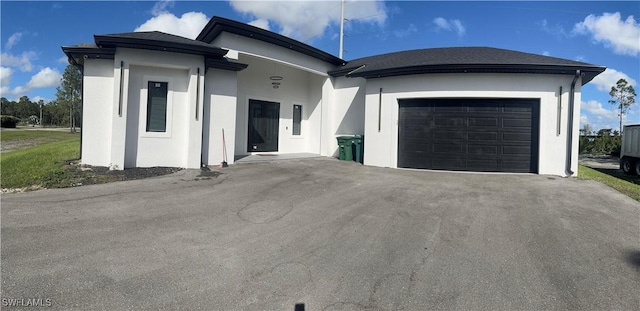 ranch-style house with driveway, an attached garage, and stucco siding