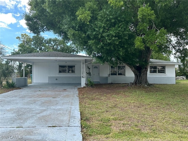 ranch-style home with concrete driveway, brick siding, a front lawn, and an attached carport