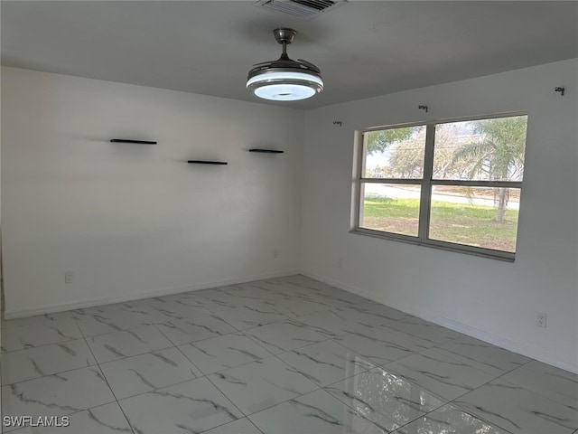 empty room featuring marble finish floor, visible vents, and baseboards