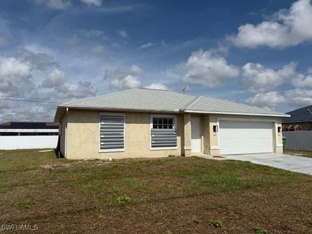 single story home featuring a front lawn, driveway, an attached garage, and stucco siding