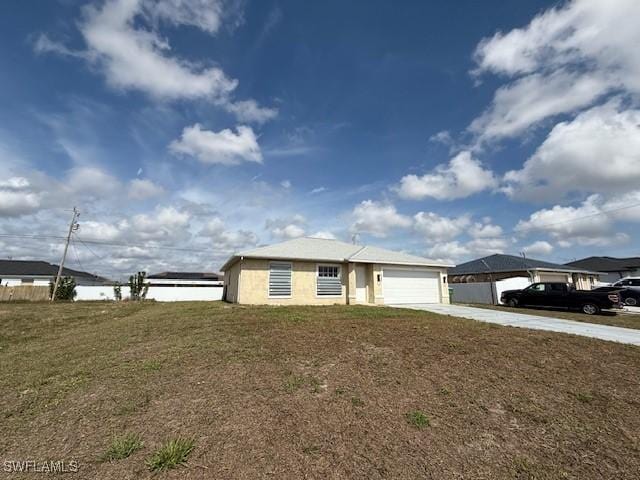 view of front of house with a garage, a front lawn, and concrete driveway