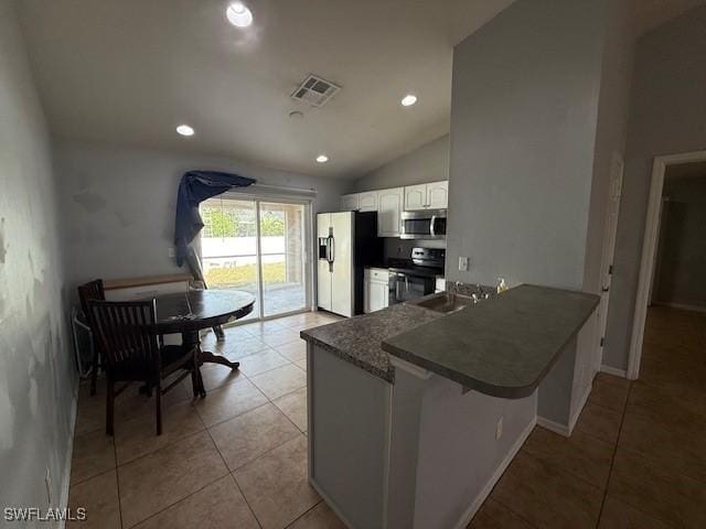 kitchen featuring dark countertops, stainless steel microwave, stove, white cabinetry, and fridge with ice dispenser