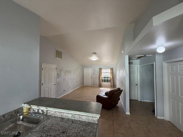 living room with visible vents, vaulted ceiling, baseboards, and light tile patterned floors