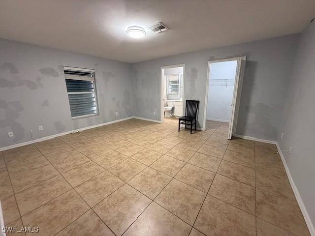 unfurnished room with light tile patterned floors, baseboards, and visible vents