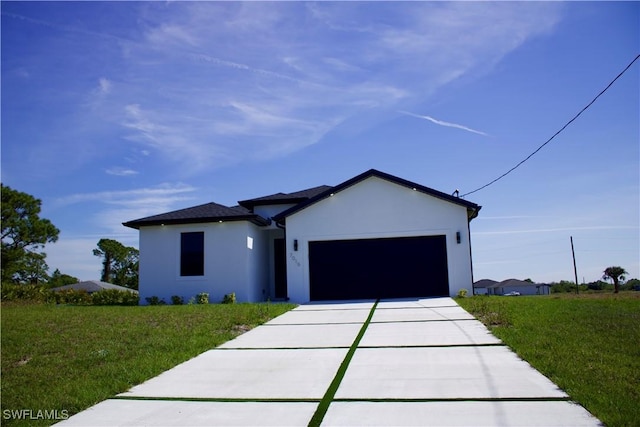 view of front of property with driveway, a front lawn, an attached garage, and stucco siding