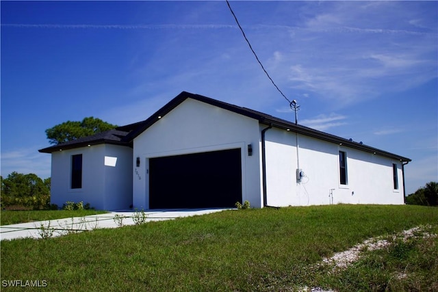 view of side of home with a garage, a lawn, and stucco siding