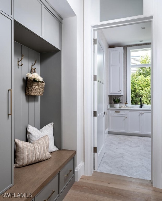 mudroom featuring light wood-type flooring and a sink