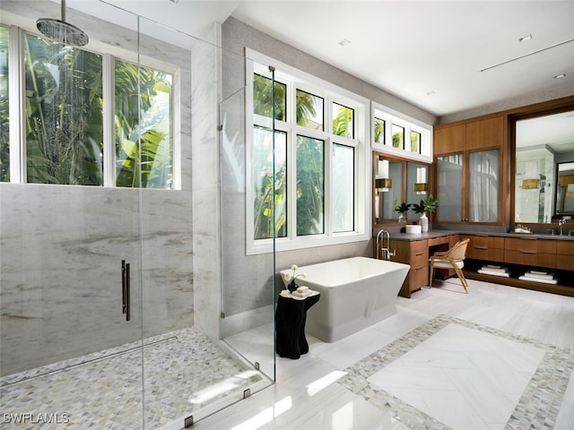 bathroom featuring a soaking tub, vanity, and a marble finish shower