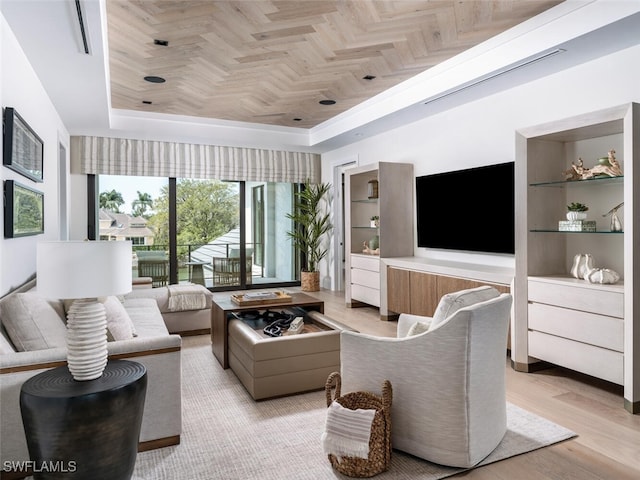 living room featuring a raised ceiling and light wood-style floors