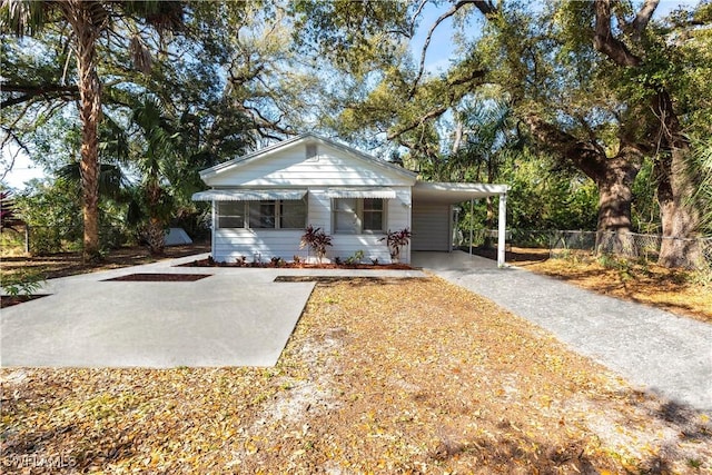 view of front of property with driveway, fence, and a carport