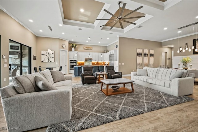 living area with crown molding, visible vents, light wood-style flooring, ceiling fan, and coffered ceiling