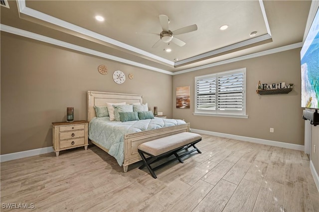 bedroom featuring ceiling fan, baseboards, light wood-type flooring, a raised ceiling, and crown molding