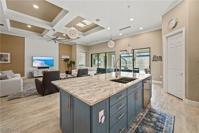 kitchen with a center island with sink, pendant lighting, open floor plan, and a sink