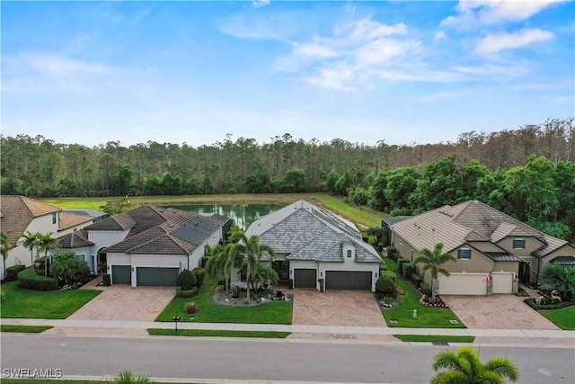 drone / aerial view featuring a water view and a wooded view