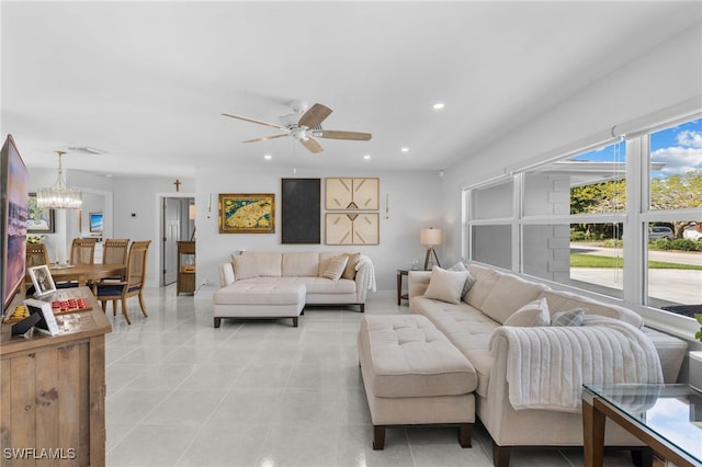 living area featuring light tile patterned floors, ceiling fan with notable chandelier, visible vents, and recessed lighting