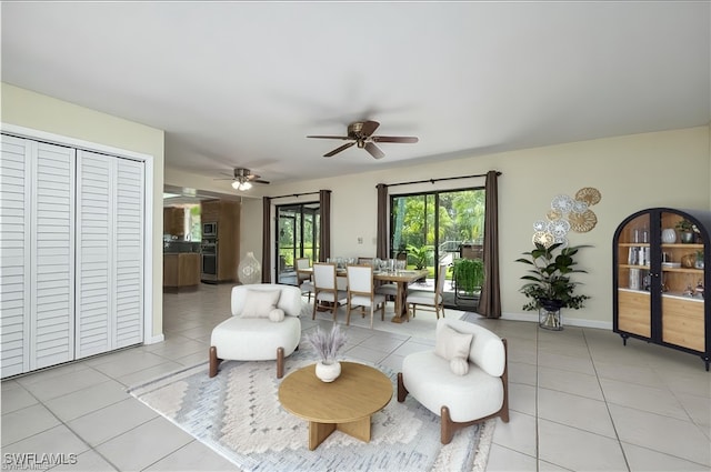 living room featuring light tile patterned floors, a ceiling fan, and baseboards