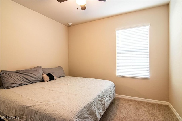 carpeted bedroom featuring ceiling fan and baseboards