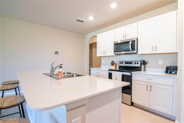 kitchen with an island with sink, stainless steel appliances, and a sink