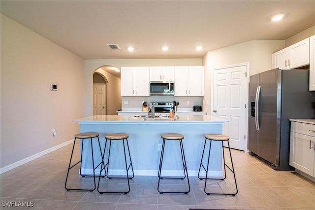 kitchen with visible vents, a kitchen island with sink, appliances with stainless steel finishes, and light countertops