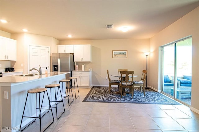 kitchen featuring light countertops, white cabinetry, visible vents, and a kitchen breakfast bar