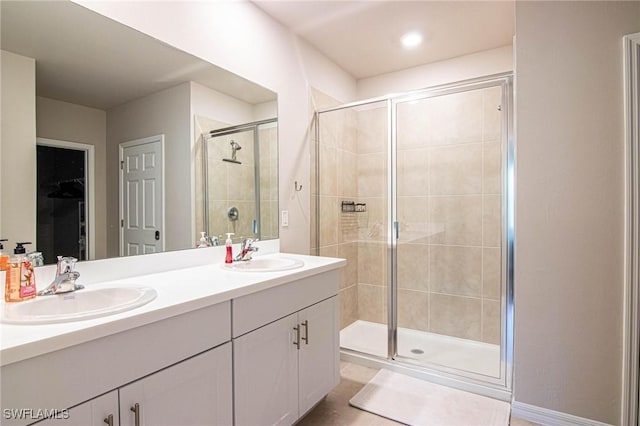 full bathroom featuring double vanity, a sink, and a shower stall