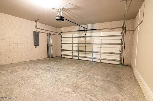 garage featuring concrete block wall, electric panel, and a garage door opener