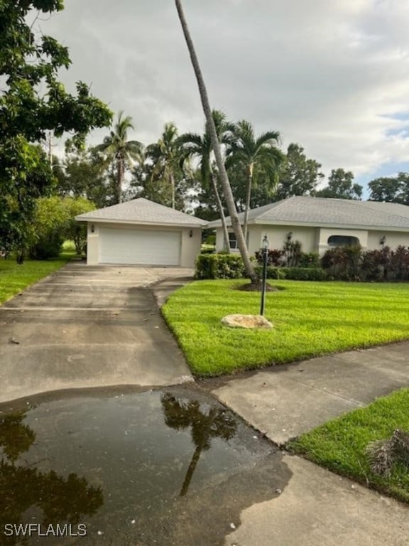 view of front facade with a garage, stucco siding, and a front yard