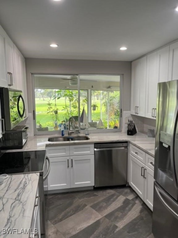 kitchen with stainless steel appliances, white cabinets, and a sink