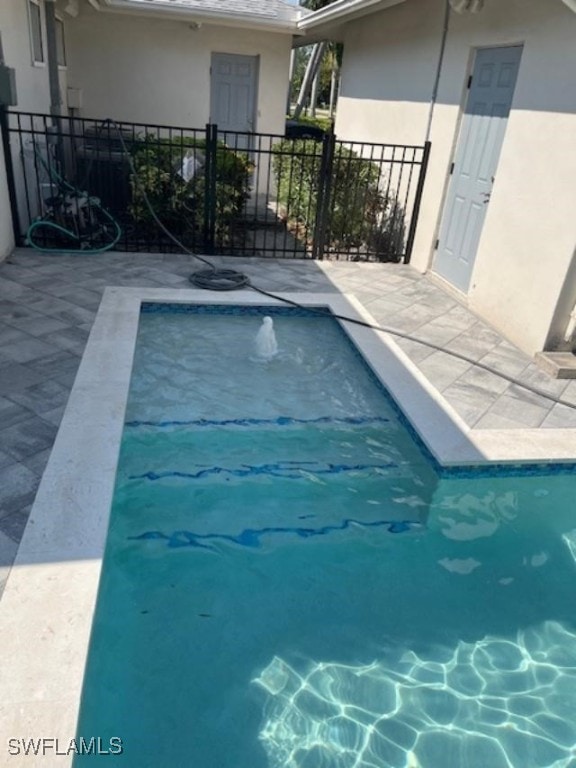 view of swimming pool featuring a patio area and fence