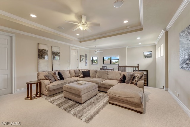 living room featuring baseboards, a tray ceiling, ceiling fan, and light colored carpet