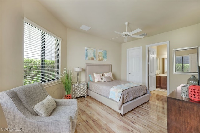 bedroom featuring light wood-type flooring, visible vents, a ceiling fan, and ensuite bathroom