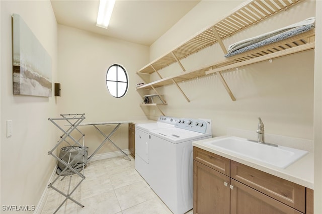 laundry room featuring cabinet space, baseboards, independent washer and dryer, a sink, and light tile patterned flooring